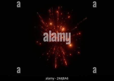 Red night fireworks bright sparkles and shiny festival explosion, glittering motion of sky fire. Motion blur fireworks twinkle at evening christmas ho Stock Photo
