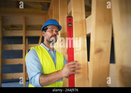 Carpenter checking wooden planks with spirit level, diy eco-friendly homes concept. Stock Photo