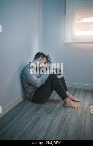 Man with problems resting sitting on the floor Stock Photo