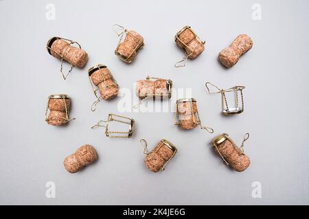 Champagne corks and metal wire muselets on grey background. Collection of bottle caps from sparkling wine . Stock Photo