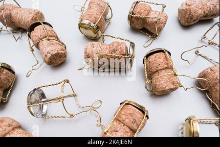 Champagne corks and metal wire muselets on grey background. Collection of bottle caps from sparkling wine . Stock Photo