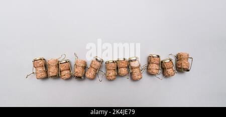 Champagne corks and metal wire muselets on grey background. Collection of bottle caps from sparkling wine . Stock Photo