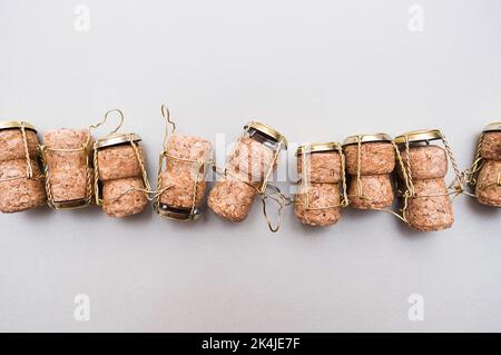 Champagne corks and metal wire muselets on grey background. Collection of bottle caps from sparkling wine . Stock Photo