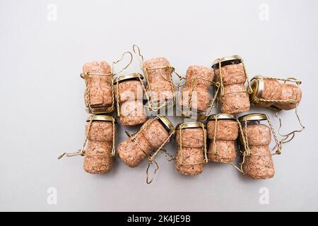 Champagne corks and metal wire muselets on grey background. Collection of bottle caps from sparkling wine . Stock Photo