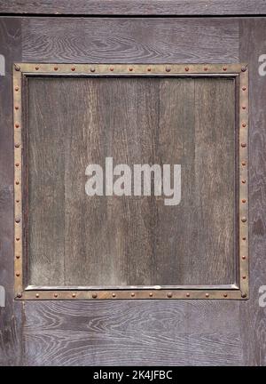 Texture of vintage wood boards with medieval metal decorative border. Vertical retro background with old wooden planks and metalic frame. Mock up temp Stock Photo