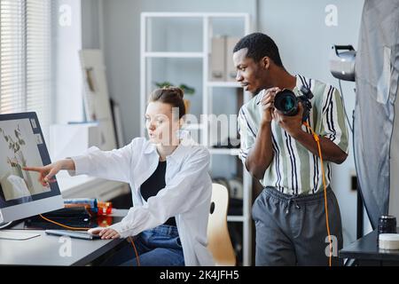 Portrait of two photographers working as team on product photoshoot in studio Stock Photo