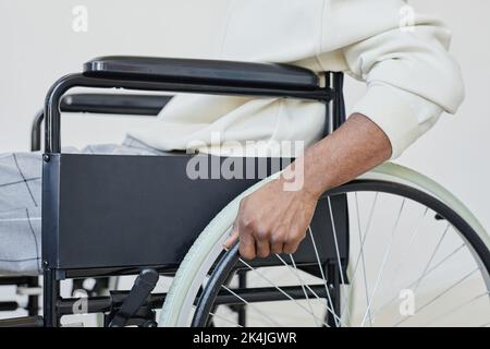 Side view closeup of young man using wheelchair against white, copy space Stock Photo