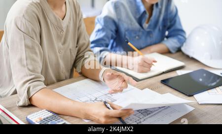 Engineering construction concept, Two female engineers is discussing construction and taking notes. Stock Photo