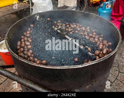 Malaysia, July 10, 2022 - Chestnuts being roasted outdoors at market. Stock Photo