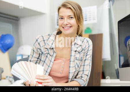 designers hand choosing color from various color swatches in office Stock Photo