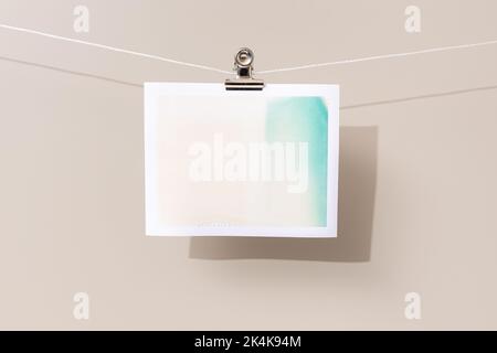 instant photo frame with green and beige patches hanging on a rope Stock Photo