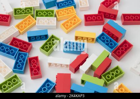 Flat lay of a table on which there are many building blocks of assorted colors made of plastic Stock Photo