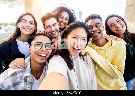 Diverse group of happy young best friends having fun taking selfie together Stock Photo