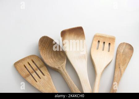Five natural wooden and bamboo kitchen shovels and spatulas on white background Stock Photo