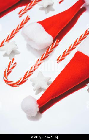 Reflected image of christmas classic decorations with candy canes, santas hat and white stars over a mirror Stock Photo