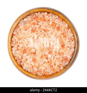 Himalayan salt, coarse crystals, in a wooden bowl. Rock salt, halite, with a pinkish tint, due to trace minerals, mined from the Punjab region. Stock Photo