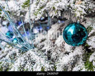 Christmas decoration. Traditional festive decorations on a snow-covered Christmas tree. Stock Photo