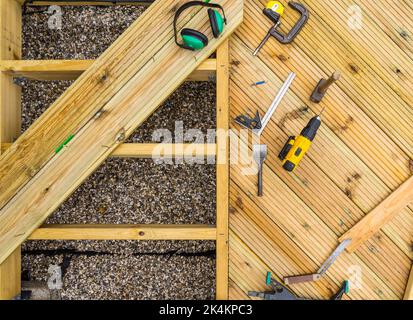 Deck under construction, showing decking joists, planks and deck tools Stock Photo