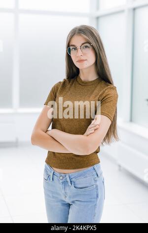 smiling young woman standing in bright office . Stock Photo