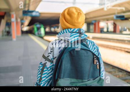 Back view caucasian woman traveler with backpack in the railway Stock Photo
