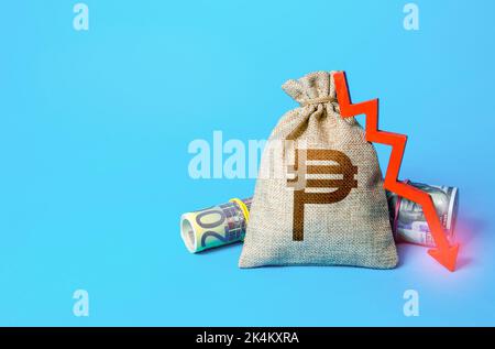 Philippine peso money bag and arrow down. Falling economy. Drop in profits. Decrease in interest rate deposit rate. Inflation. Low real incomes, econo Stock Photo