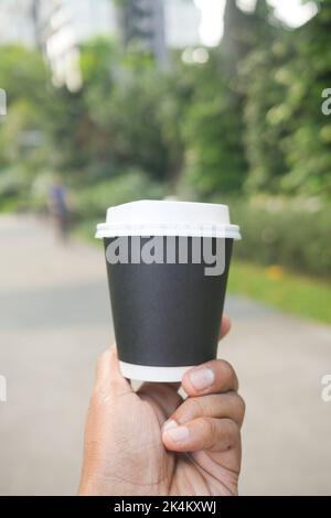 holding a take away paper coffee cup outdoor  Stock Photo