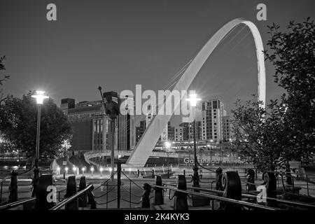 The curved arch of the Gateshead Millennum Bridge spanning the River Tyne joining Newcastle and Gateshead. Captured during early evening blue hour and Stock Photo