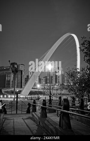 The curved arch of the Gateshead Millennum Bridge spanning the River Tyne joining Newcastle and Gateshead. Captured during early evening blue hour and Stock Photo