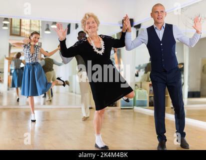 Mature woman dancing swing with young man Stock Photo
