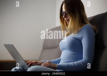 Woman working on laptop at night. Freelance writer person typing text on modern notebook pc at home. Female programmer coding on computer Stock Photo