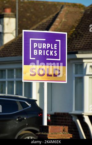 A 'Purple Bricks' online estate agents 'Sold' sign outside a suburban house in Shepperton Surrey England UK Stock Photo