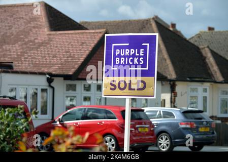 A 'Purple Bricks' online estate agents 'Sold' sign outside a suburban house in Shepperton Surrey England UK Stock Photo