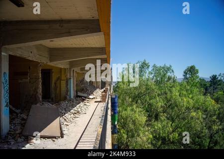 demolition of walls, in a building you can see half of the construction and the trees and sky. concrete walls and roofs Stock Photo