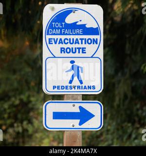 Carnation, WA, USA - October 02, 2022; Pedestrian evacuation sign for Tolt Dam Failure in Carnation with arrow in blue and white Stock Photo