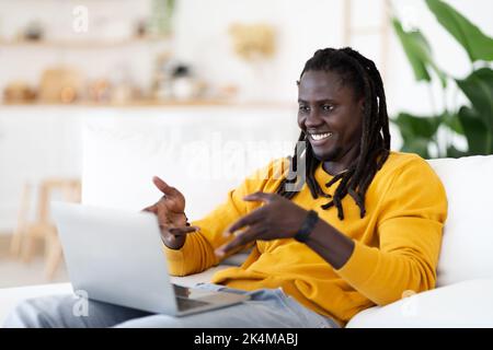Distant Communication. Smiling Black Man Making Video Call On Laptop At Home Stock Photo