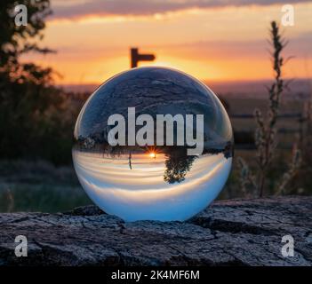 Sunset viewed through a glass lens ball Stock Photo
