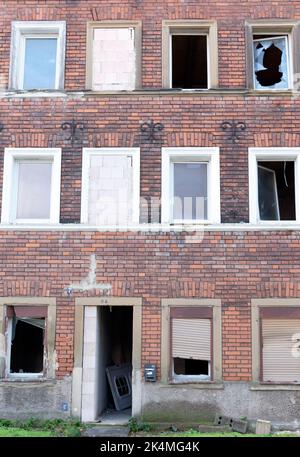 Symbolic image: Abandoned. empty, past, broken: neglected brick house facade with empty, broken windows Stock Photo
