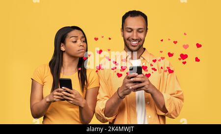 Suspicious black woman trying to look at her boyfriend's smartphone Stock Photo