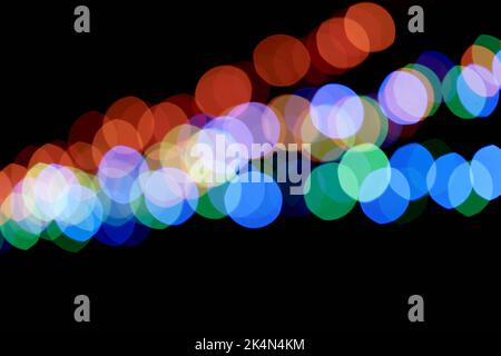 Abstract magic background with bokeh effect. Three multicolored garlands, defocused bokeh lights on an isolated black background. To overlay your design. High quality photo Stock Photo