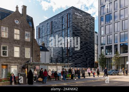 1 October 2022. Aberdeen, Scotland. This is people waiting for a bus to take them home from Aberdeen City Centre with the Marriott Inn Hotel in the ba Stock Photo