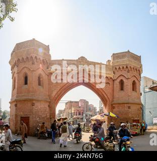 MULTAN, PAKISTAN - FEBRUARY 22, 2020 : Delhi Gate Picturesque View with Rickshaw Walking People and Motorbikes on a Sunny Day Stock Photo