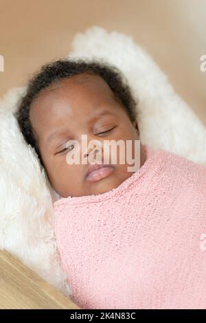 Black african baby girl taking a nap wrapped up studio close up Stock Photo