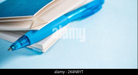 Blue pen in a notebook on blue background Stock Photo