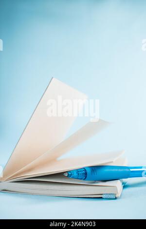 Blue pen in a notebook on blue background Stock Photo