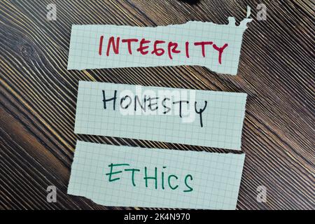 Concept of Integrity, Honesty and Ethics write on sticky notes isolated on Wooden Table. Stock Photo