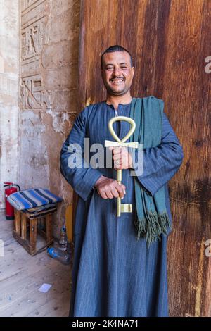 Abu Simbel, Aswan, Egypt. February 22, 2022. Caretaker holding a large key in the shape of an anhk at the Great Temple of Ramesses II. Stock Photo