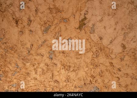 Mud plaster wall background texture. Dry brown empty soil ground, floor structure, blank cracked surface for backdrop. Copy space. Stock Photo