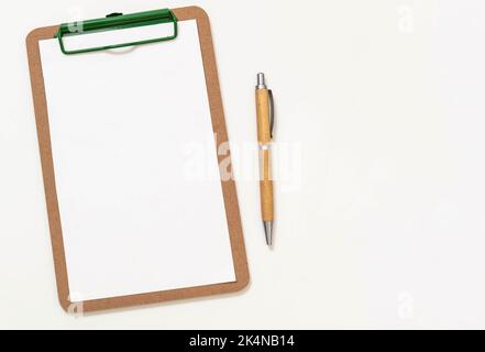 Wooden clipboard with empty paper and wood cover pen isolated cutout on white background. Space for text clipping path. Advertising template Stock Photo
