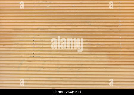 Vintage orange color empty roller shutter door background texture. Metal garage door construction, faded old closed foldable, safety. Copy space Stock Photo