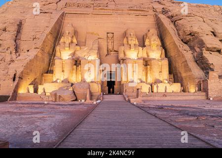 Abu Simbel, Aswan, Egypt. February 23, 2022. Lights on the colossal statues of the Great Temple of Ramesses II in early morning. Stock Photo